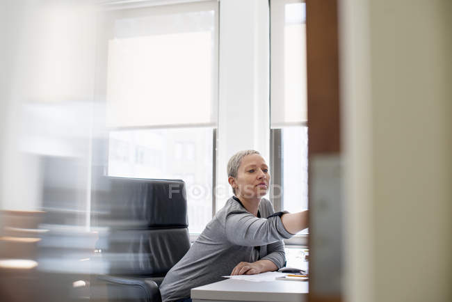 Frau arbeitet allein im Büro — Stockfoto