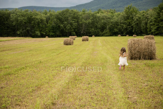 Menina por um grande haybale — Fotografia de Stock