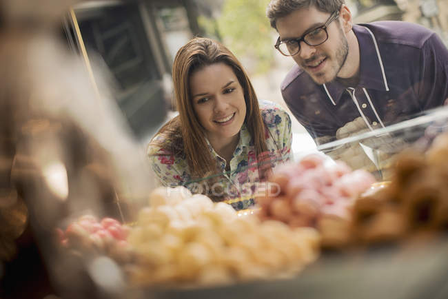 Couple looking on confectionery shop. — Stock Photo