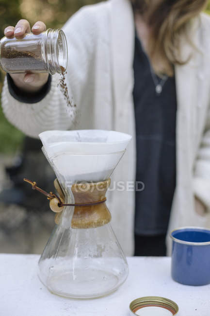 Frau gießt gemahlenen Kaffee ein — Stockfoto