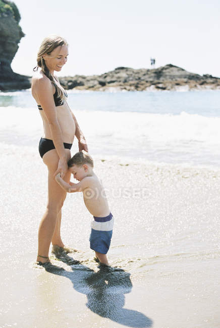 Donna in bikini che gioca con suo figlio — Foto stock