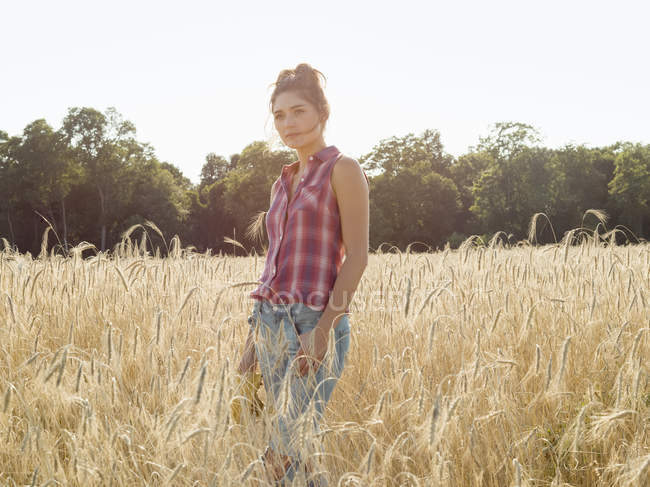 Mujer de pie en un campo de trigo - foto de stock