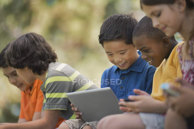 Crianças usando tablets e jogos de mão . — Fotografia de Stock