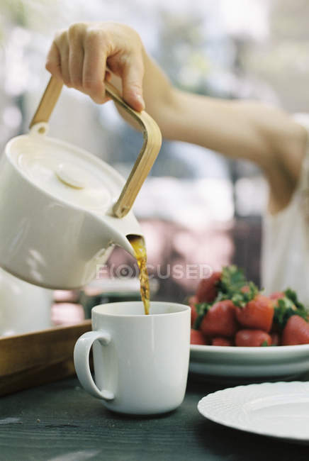 Versare una tazza di tè . — Foto stock