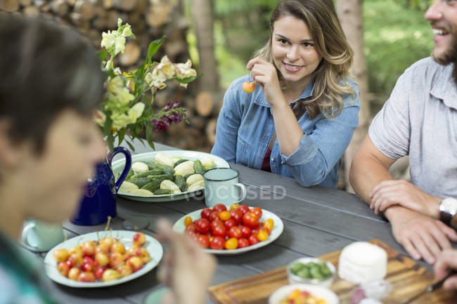 Three people seated at a table outdoors — Stock Photo