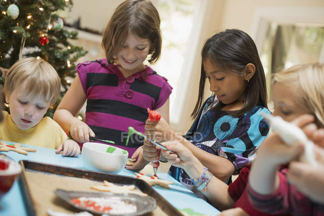 Niños decorando galletas orgánicas de Navidad - foto de stock