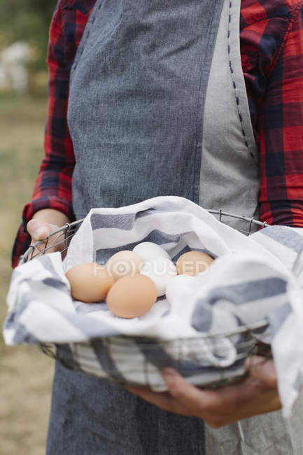 Femme tenant un bol d'œufs frais . — Photo de stock