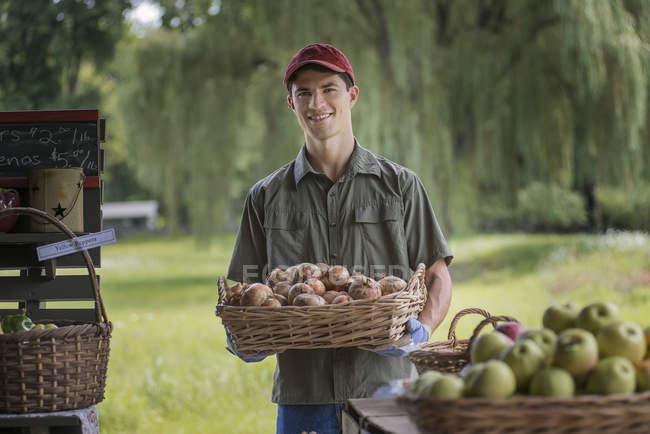Man holding baskets of fresh fruit — Stock Photo