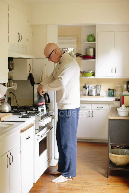 Чоловік стоїть на кухні — стокове фото