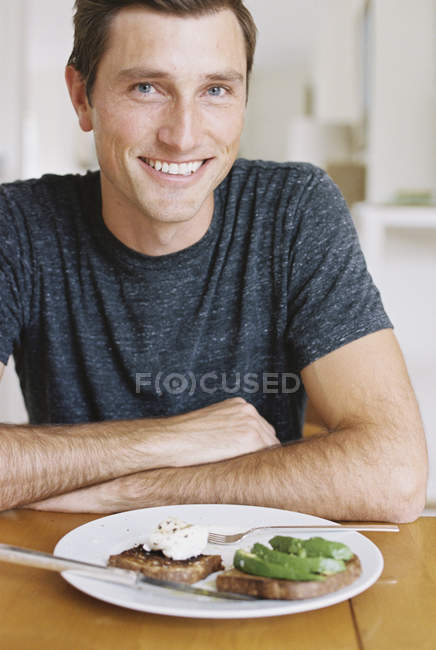 Man sitting in front of a plate — Stock Photo