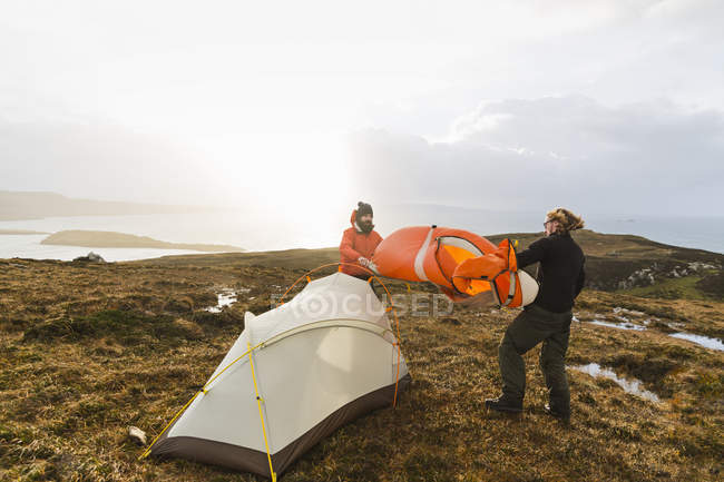Uomini che tengono e montano una piccola tenda — Foto stock