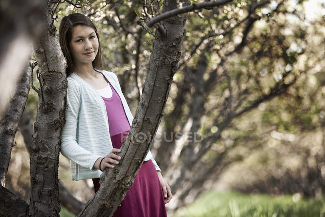 Mädchen lehnt an Baum — Stockfoto