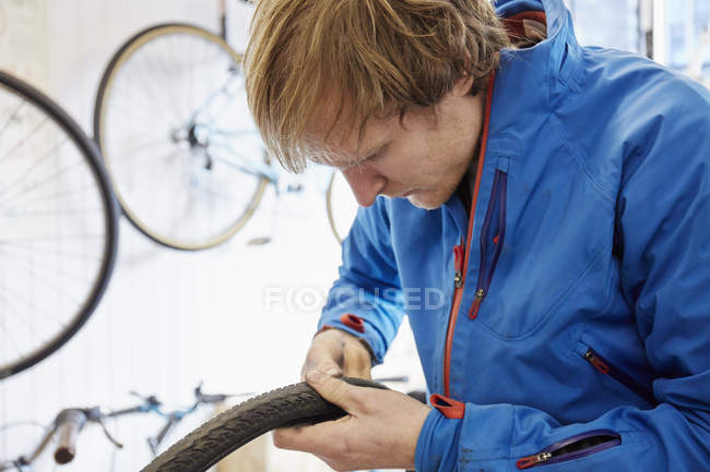 Hombre que trabaja en una tienda de bicicletas - foto de stock