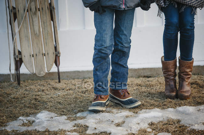 Мальчик и девочка стоят во дворе зимой . — стоковое фото