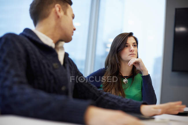 Hombre y mujer sentados en una reunión - foto de stock