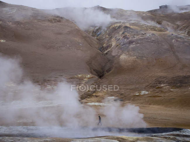 Person at steamy edge of a hot spring. — Stock Photo