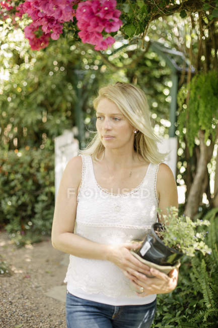 Mulher segurando um vaso de planta . — Fotografia de Stock