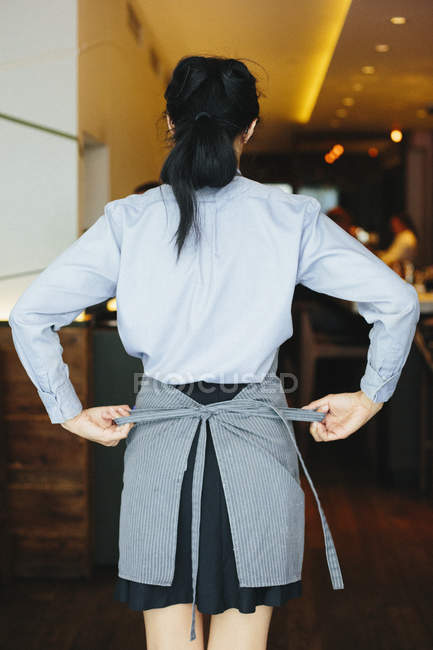 Garçonete amarrando avental — Fotografia de Stock