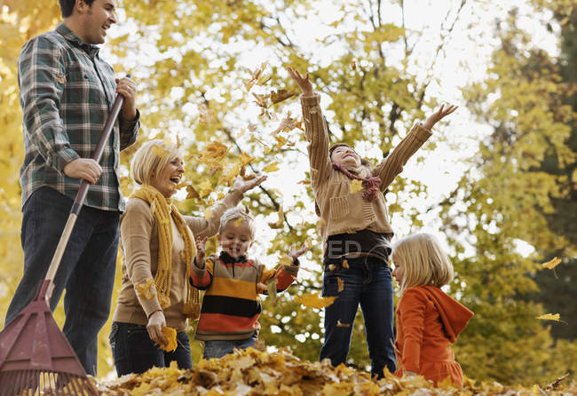 Семья играет в осенние листья . — стоковое фото