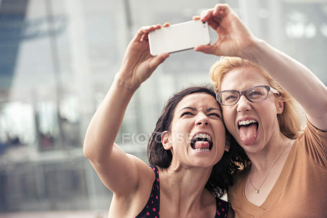 Mulheres em uma rua de cidade, tirando uma selfie — Fotografia de Stock
