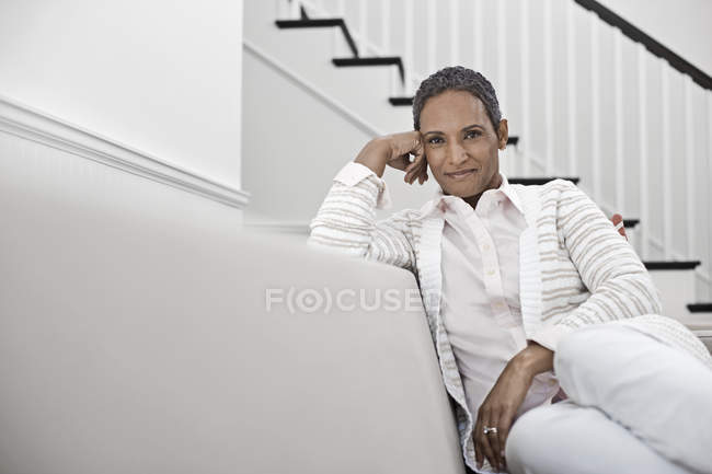 Жінка сидить на дивані — стокове фото