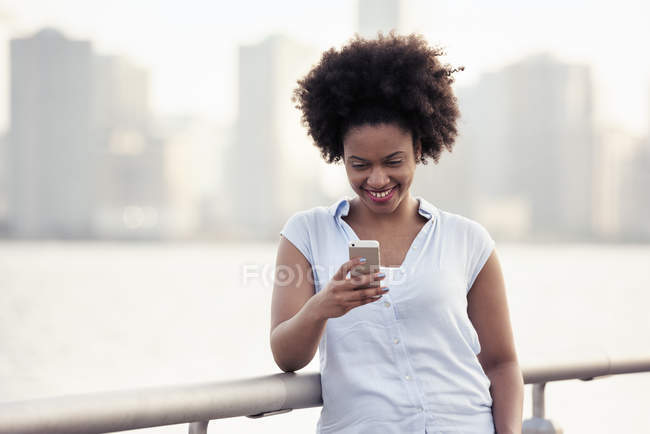 Femme vérifiant son téléphone portable — Photo de stock