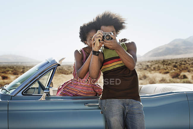 Paar bei einem hellblauen Cabrio — Stockfoto