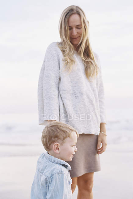 Mujer con su pequeño hijo junto al océano - foto de stock