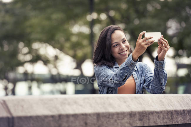 Mulher tomando selfie com um telefone inteligente — Fotografia de Stock