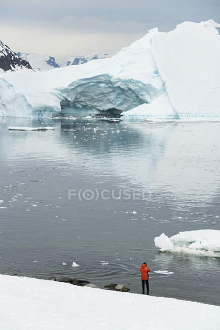 Homme debout sur le rivage enneigé de l'Antarctique — Photo de stock