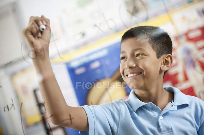 Junge schreibt wissenschaftliche Gleichungen — Stockfoto