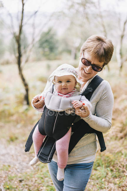 Woman carrying a baby — Stock Photo