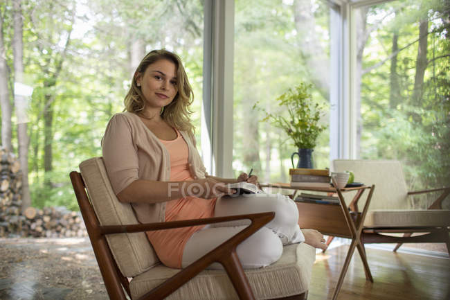 Woman seated holding an open journal — Stock Photo