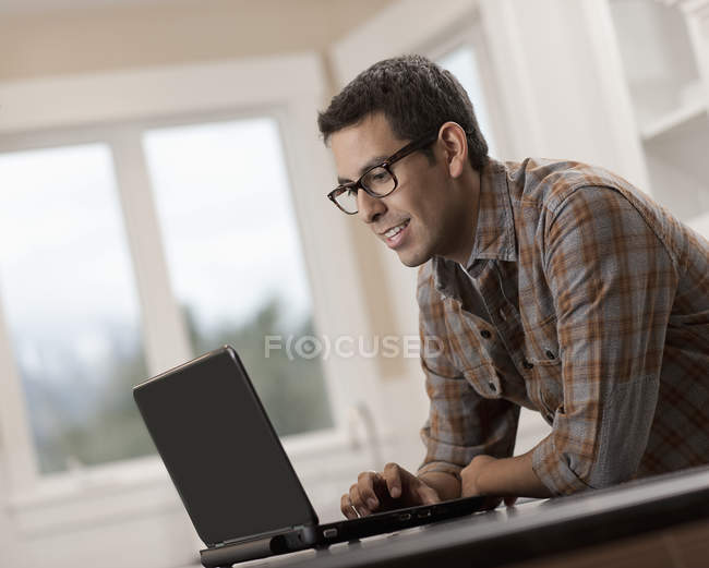 Hispânico homem usando um computador portátil . — Fotografia de Stock