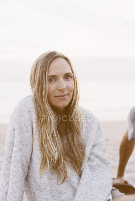 Woman sitting on a sandy beach — Stock Photo