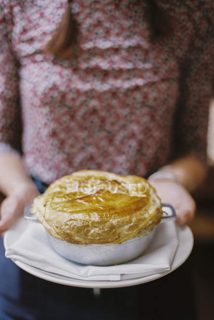Woman carrying a fresh baked pie — Stock Photo