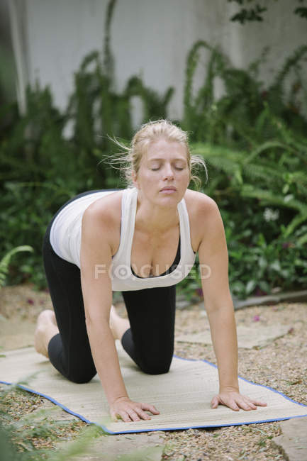 Mujer haciendo yoga en un jardín
. - foto de stock