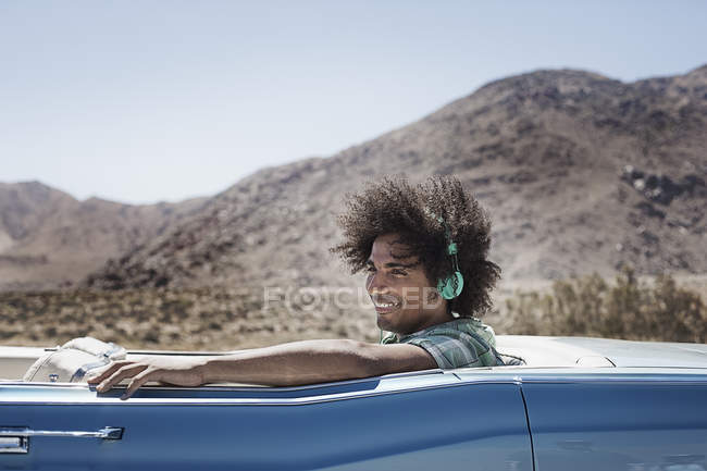 Homme avec écouteurs de musique en voiture — Photo de stock