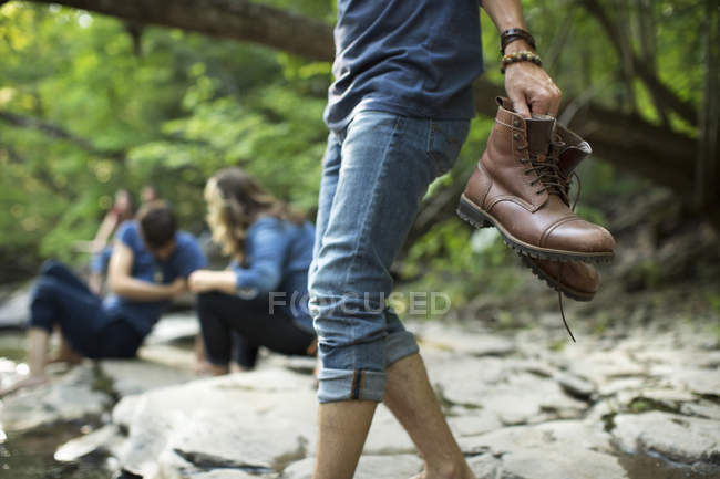 Homem carregando suas botas — Fotografia de Stock