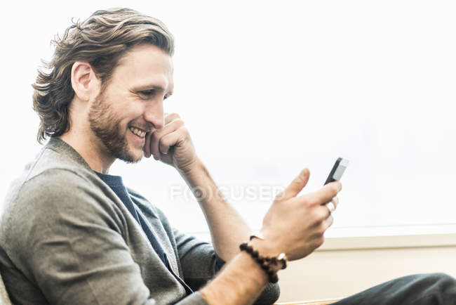 Homme barbu assis souriant — Photo de stock