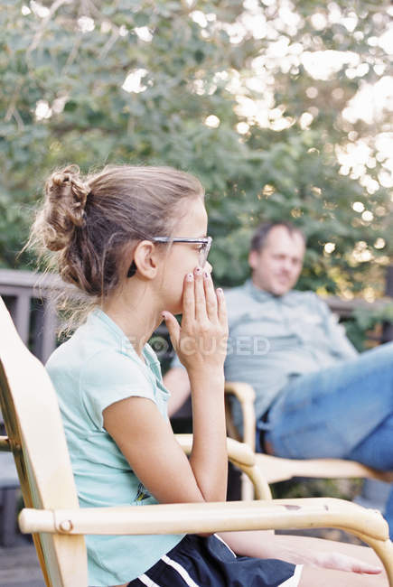 Mann und ein junges Mädchen sitzen in einem Garten. — Stockfoto