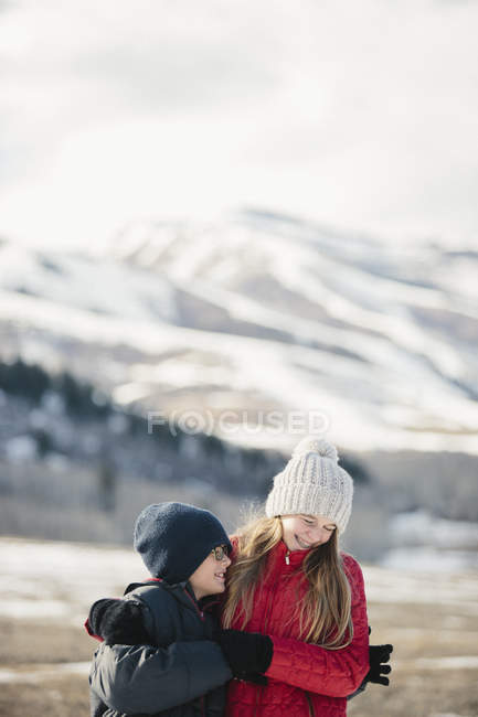 Hermano y hermana abrazando y riendo - foto de stock