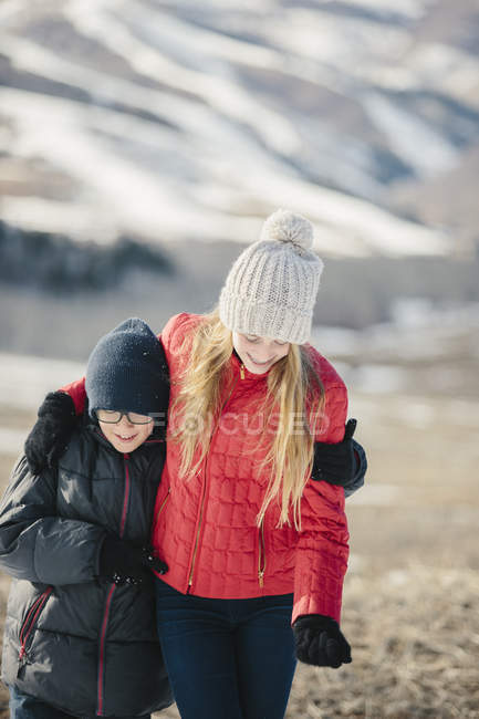 Брат и сестра обнимаются и смеются — стоковое фото