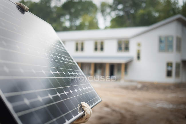 Workman carrying a large solar panel — Stock Photo