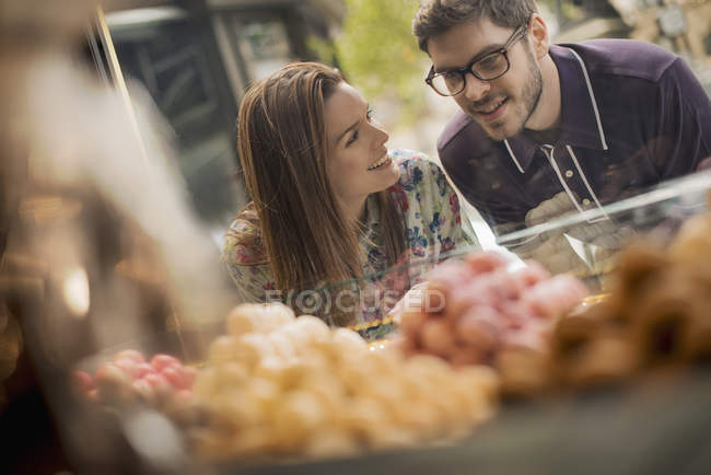 Coppia guardando negozio di dolciumi
. — Foto stock