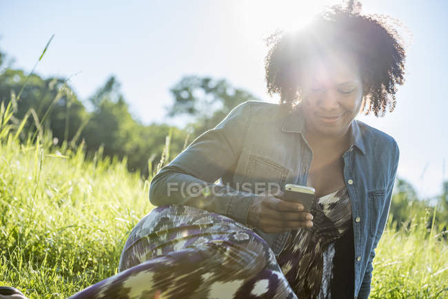 Mujer revisando su teléfono inteligente - foto de stock