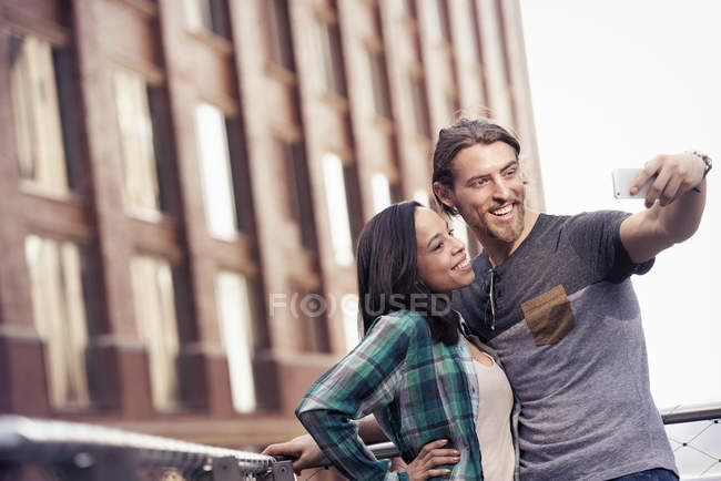 Мужчина и женщина делают селфи в городе — стоковое фото