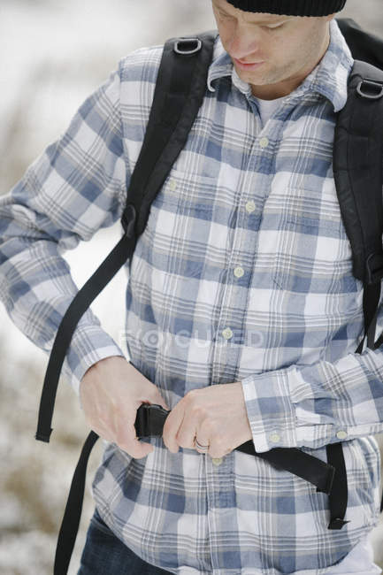 Hiker fastening the belt securing backpack. — Stock Photo