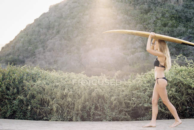 Mulher carregando surfboar — Fotografia de Stock