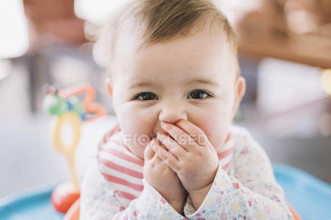 Bébé fille avec mains couvrant la bouche — Photo de stock
